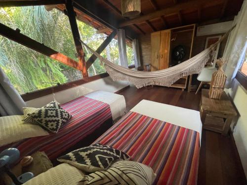 a bedroom with a hammock in a tree house at Vila Pitanga - Arandis in Marau