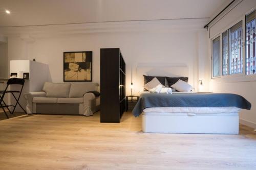 a bedroom with a bed and a couch and a chair at Bcn - Loft Parc Guell in Barcelona