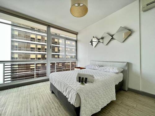 a bedroom with a bed and a large window at Boutique Apartments Panama Atlapa in Panama City