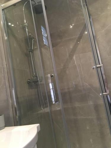 une douche avec une porte vitrée dans une salle de bain dans l'établissement ​Cœur de ville ! Cœur de l'Oise​​ ! Moderne & fonctionnel​, à Clermont