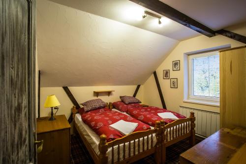 Schlafzimmer mit einem Bett mit roter Bettwäsche und einem Fenster in der Unterkunft Cactus Snežienka in Regetovka