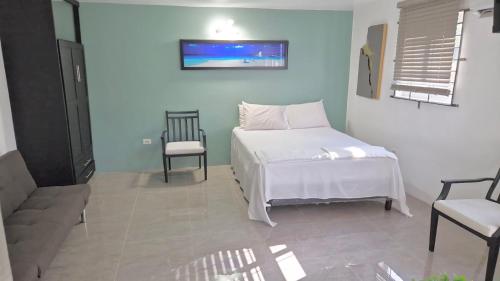 a bedroom with a white bed and a chair at Amharic in Kingston