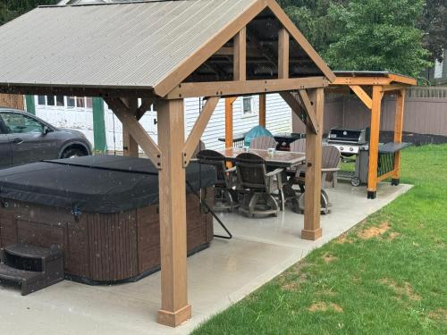 a wooden gazebo with a table and a grill at Berrodin Bed & Breakfast in Akron