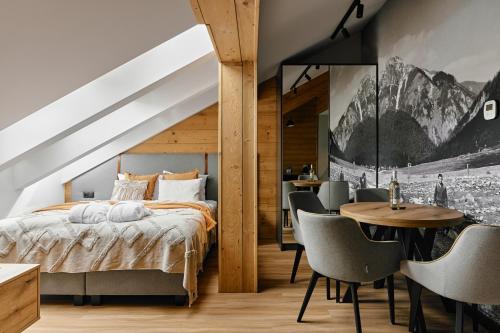 a bedroom with a bed and a table and chairs at Tatra Nest Apartamenty - jacuzzi, sauna! in Biały Dunajec