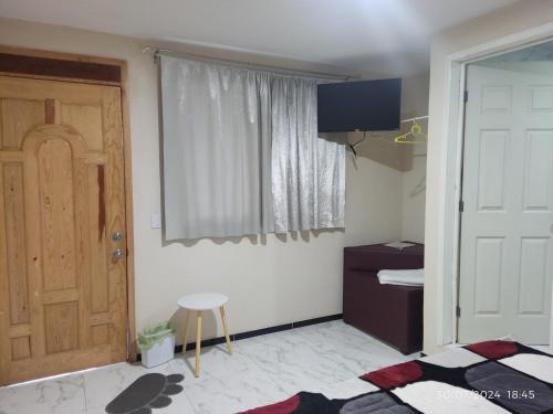 a room with a door and a window and a stool at Hotel Mextlitlán Tierra de Lunas in Zacatlán