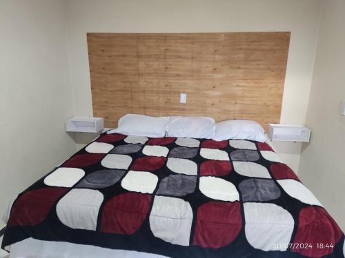 a bedroom with a black and white quilt on a bed at Hotel Mextlitlán Tierra de Lunas in Zacatlán