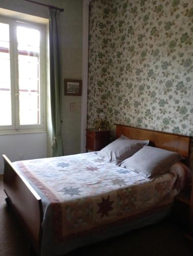 a bedroom with a bed with a floral wallpaper at Grande Maison Simone-Climatisation-Parking-Terrain in Carcassonne