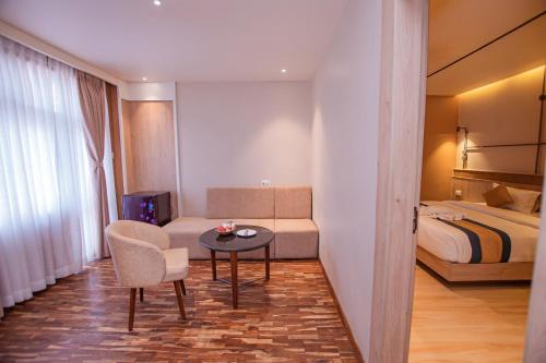 a hotel room with a bed and a table and a chair at Hotel Vistara in Kathmandu