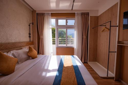 a bedroom with a bed with a large window at Hotel Vistara in Kathmandu