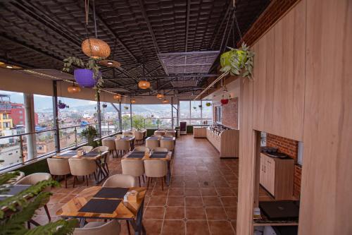 a restaurant with tables and chairs on a balcony at Hotel Vistara in Kathmandu