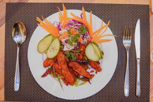 a plate of food with a salad and vegetables at Hotel Vistara in Kathmandu