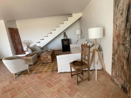 a living room with a staircase and a chair at Quinta do Coelhoazul in Quelfes