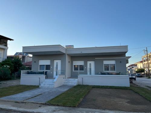 a small white house on the side of a street at Astron Apartments in Keramotí