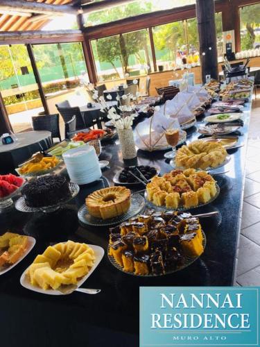 einem langen Tisch mit verschiedenen Lebensmitteln in der Unterkunft Nannai Residence - Apartamento Duplex in Porto De Galinhas