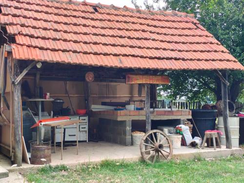 a building with an orange roof with a table and a wheel at Kuca za odmor Domacinstvo Jelkici in Zvornik
