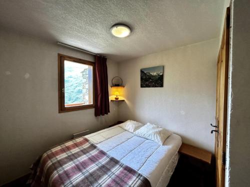 une petite chambre avec un lit et une fenêtre dans l'établissement Résidence Argentiere - Appartement 2 pièces pour 4/6 personnes MAE-3864, aux Menuires
