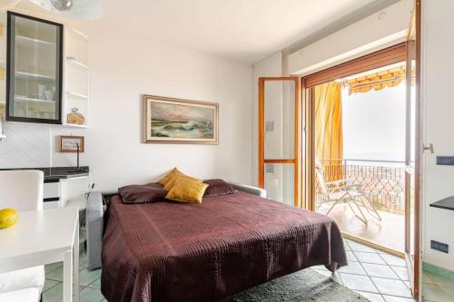 a bedroom with a bed and a balcony at TheKeyStudio, La Casa del Mare Azzurro with seaview in Ventimiglia