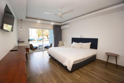a bedroom with a large bed and a large window at Dunama Hotel in Playa Flamingo