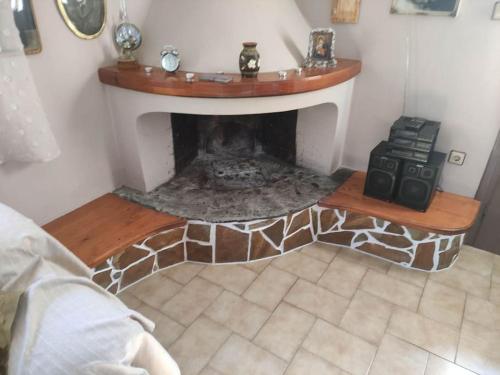 a living room with a stone fireplace in a room at Anastasia's house in Oktonía