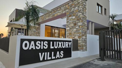 a house with a sign that reads oasis luxury villas at STAY Oasis Luxury Villas in Ayia Napa