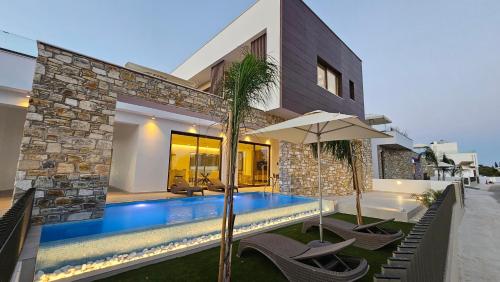 a villa with a swimming pool and a house at STAY Oasis Luxury Villas in Ayia Napa