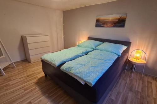 a bedroom with a bed with blue sheets and two lamps at Urlaub in Duckwitz - Familienfreundliche Ferienwohnung in Seenähe in Behren-Lübchin