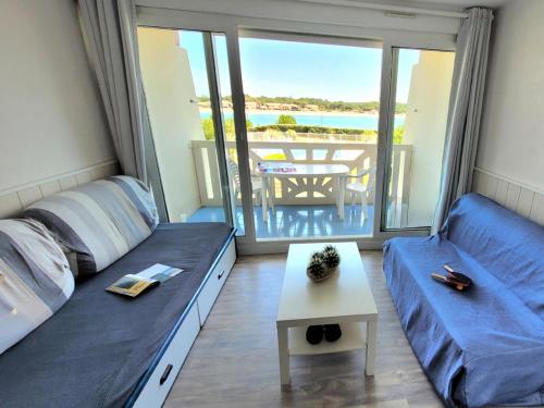 Cette chambre comprend deux lits et un balcon avec une table. dans l'établissement Résidence Le Boucanier - 2 Pièces pour 4 Personnes 134, à Vieux-Boucau-les-Bains