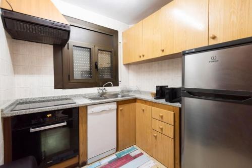a kitchen with a stainless steel refrigerator and a sink at Pis al centre de Canillo, a prop del telecabina HUT 8304 in Canillo