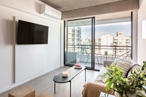 a living room with a large window and a tv at Top Rentals Nuñez in Buenos Aires