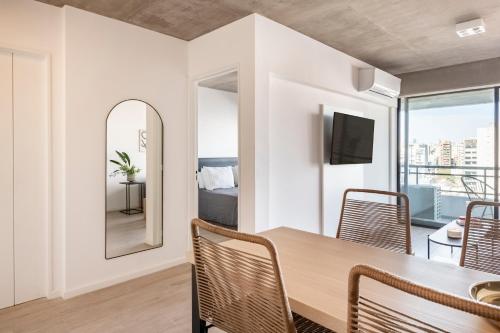 a dining room with a table and chairs and a mirror at Top Rentals Nuñez in Buenos Aires