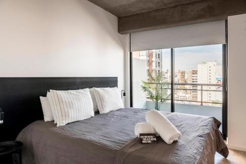 a bedroom with a large bed with a large window at Top Rentals Nuñez in Buenos Aires