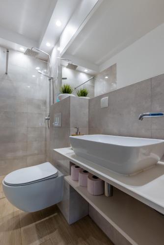 a bathroom with a tub and a toilet and a sink at PlumTree Holiday Apartment in Gdańsk