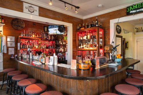a bar with stools in a room with alcohol at The Speakeasy Inn and Rum Bar in Key West