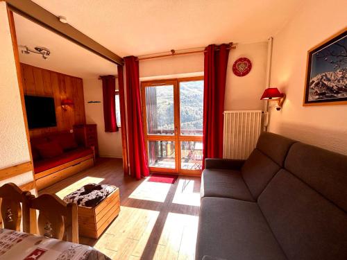 un salon avec un canapé et une fenêtre dans l'établissement Appartement économique 4 pers aux Menuires, 2 pièces, balcon, casier à skis - FR-1-452-165, aux Menuires