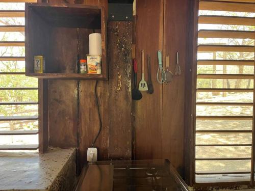 a corner of a kitchen with a counter and utensils at Surfers Paradise - Cabin next to Yankee Beach in Escamequita