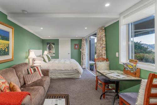 a living room with a couch and a bed at Bayview Valley Lodge Bed & Breakfast in Whitianga
