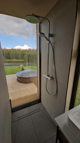 a shower in a bathroom with a tub at Pöögle Järvemaja in Pöögle
