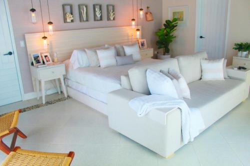 a bedroom with a white bed and a couch at Esciros in Chicxulub
