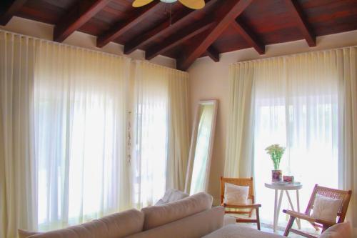 a living room with a couch and large windows at Esciros in Chicxulub