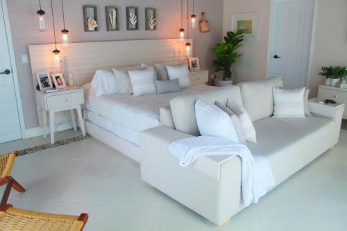 a bedroom with a white bed and a couch at Esciros in Chicxulub