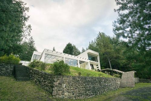 a house on a hill with a stone wall at Sienta el confort en el paraíso in Tarqui