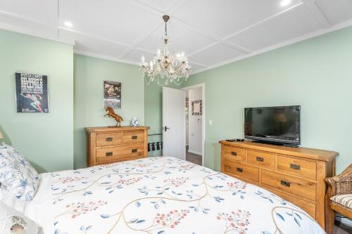 a bedroom with a bed and a flat screen tv at Bayview Valley Lodge Bed & Breakfast in Whitianga