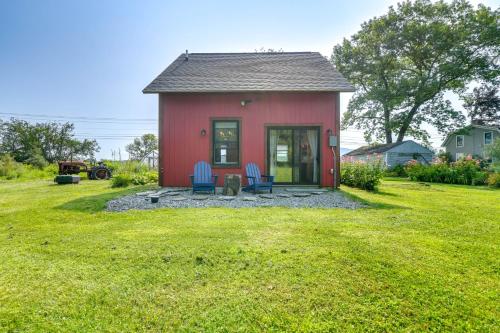 a red house with two blue chairs in the yard at Historic Charm and Modern Luxury 6 Mi to Stowe Mtn in Stowe