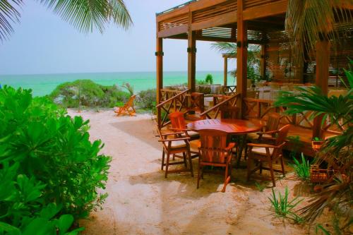a restaurant on the beach with a table and chairs at Esciros in Chicxulub