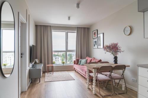 a living room with a pink couch and a table at Apartament Pełczyńskiego 3 in Warsaw