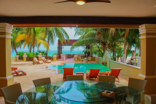 a room with a table and chairs and a pool at Esciros in Chicxulub