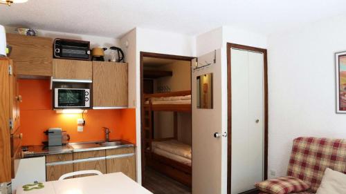 une petite cuisine avec évier et une chambre dans l'établissement Résidence Le Pouzenc - Studio équipé pour 4 personnes MAE-0501, aux Orres