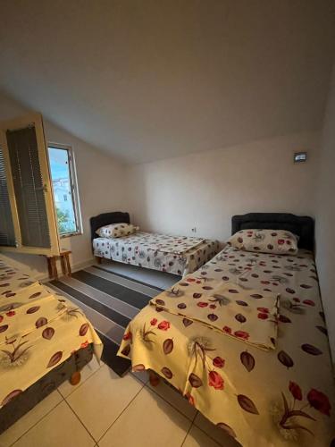 a bedroom with two beds and a window at Apartman Tara in Donji Štoj