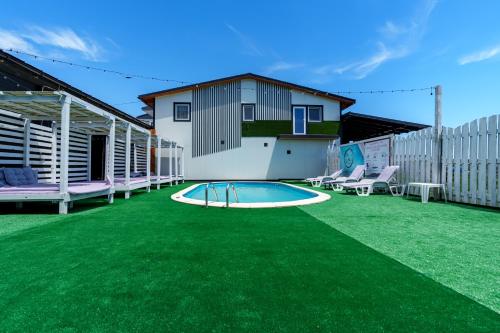 a backyard with green grass and a swimming pool at Deea Marii Costinesti in Schitul