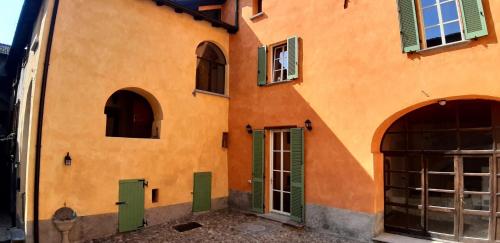 an orange building with green doors and windows at DomasHome in Domaso